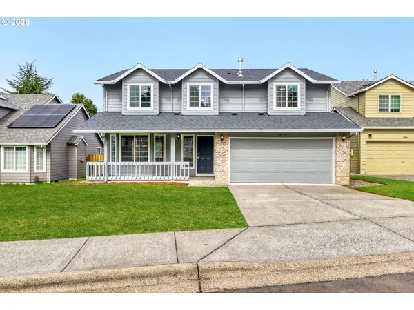 a front view of a house with a garden and yard