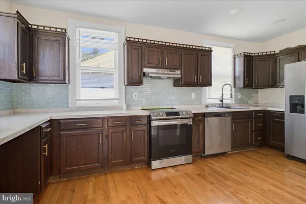a kitchen with stainless steel appliances granite countertop a sink stove and microwave