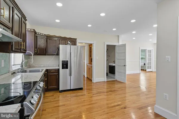 a kitchen with stainless steel appliances granite countertop a refrigerator and a stove top oven