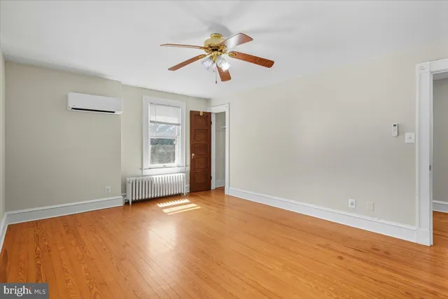 a view of a hallway with wooden floor and windows
