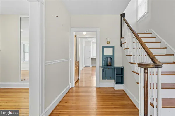 a view of a hallway with wooden floor and staircase
