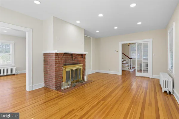 an empty room with wooden floor and fireplace