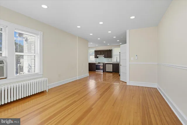 a view of a kitchen with wooden floor and a window