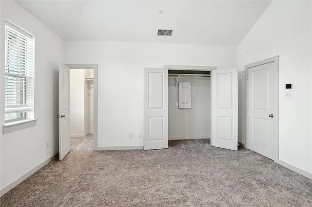 an empty room with windows and closet