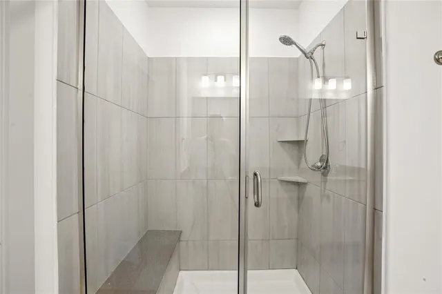 a bathroom with a glass shower door and a bathroom sink