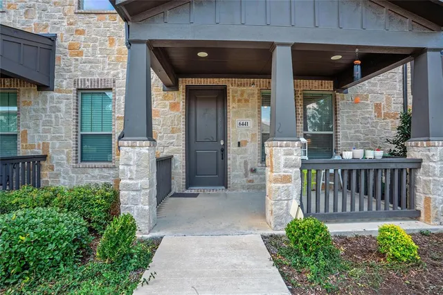 a view of a house with a small yard and wooden floor and fence