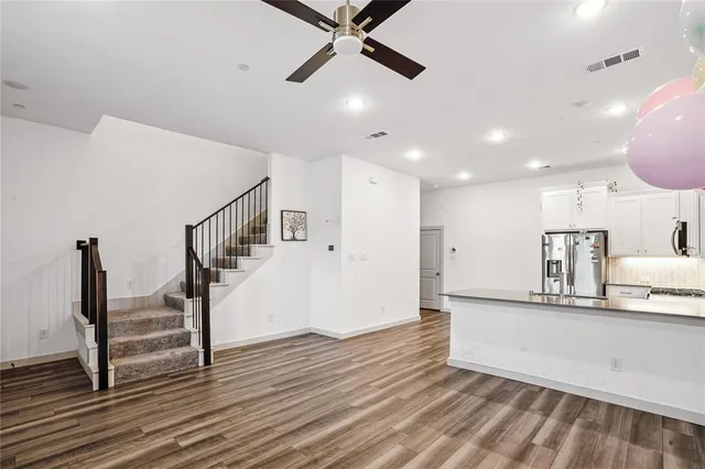 a view of a kitchen with wooden floor and a ceiling fan
