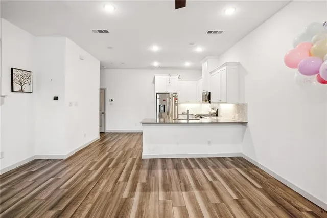 a view of kitchen with wooden floor and electronic appliances