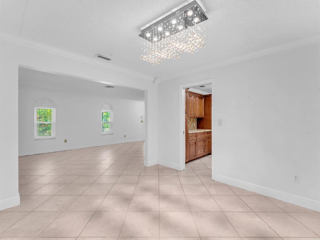 11762 Northwest 26th Court Coral Springs, FL 33065 - Photo 13 of 37 wooden floor in a room with a chandelier