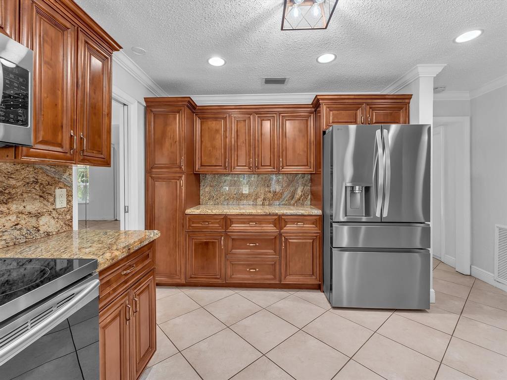 11762 Northwest 26th Court Coral Springs, FL 33065 - Photo 15 of 37 a kitchen with stainless steel appliances granite countertop a refrigerator and a stove top oven