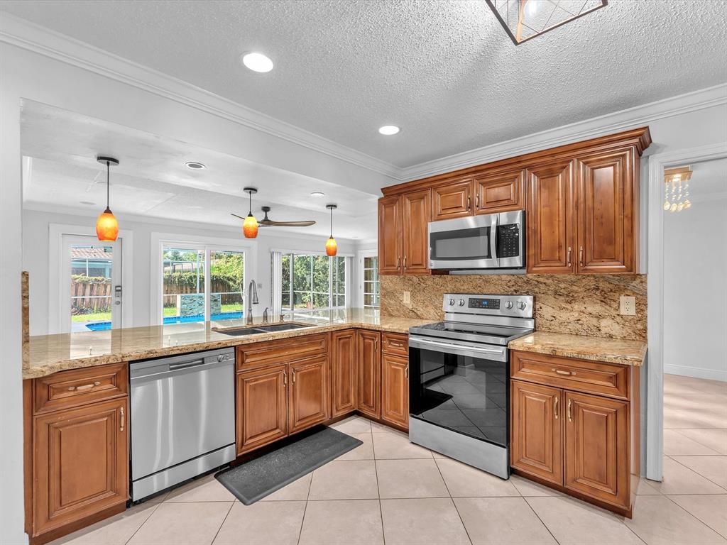 11762 Northwest 26th Court Coral Springs, FL 33065 - Photo 16 of 37 a kitchen with stainless steel appliances granite countertop a sink and stove top oven