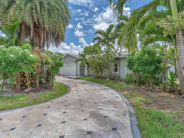 a front view of a house with a yard and a garden