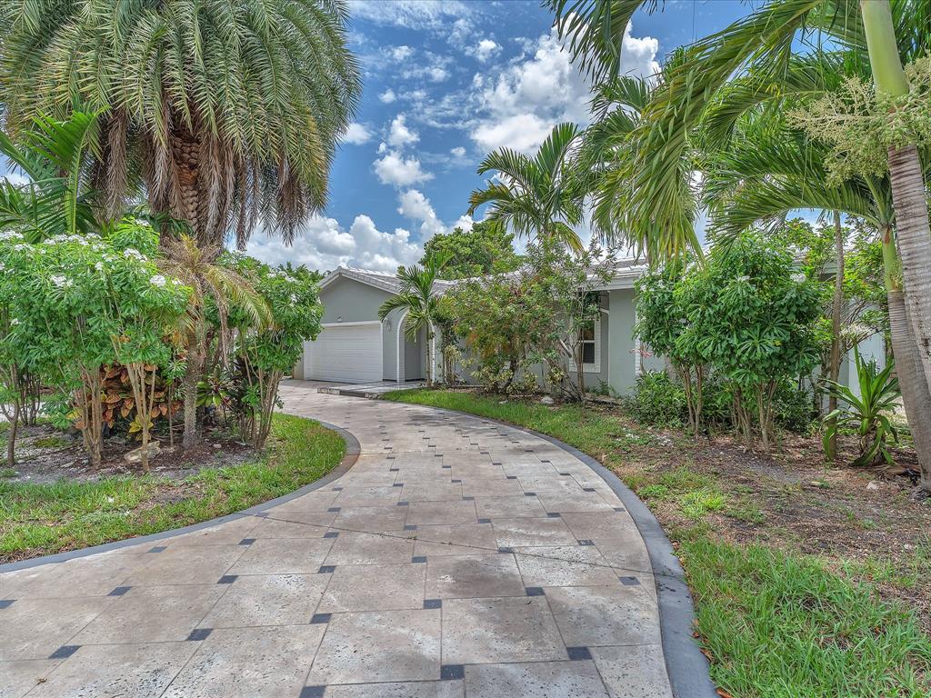11762 Northwest 26th Court Coral Springs, FL 33065 - Photo 6 of 37 a front view of a house with a yard and a garden