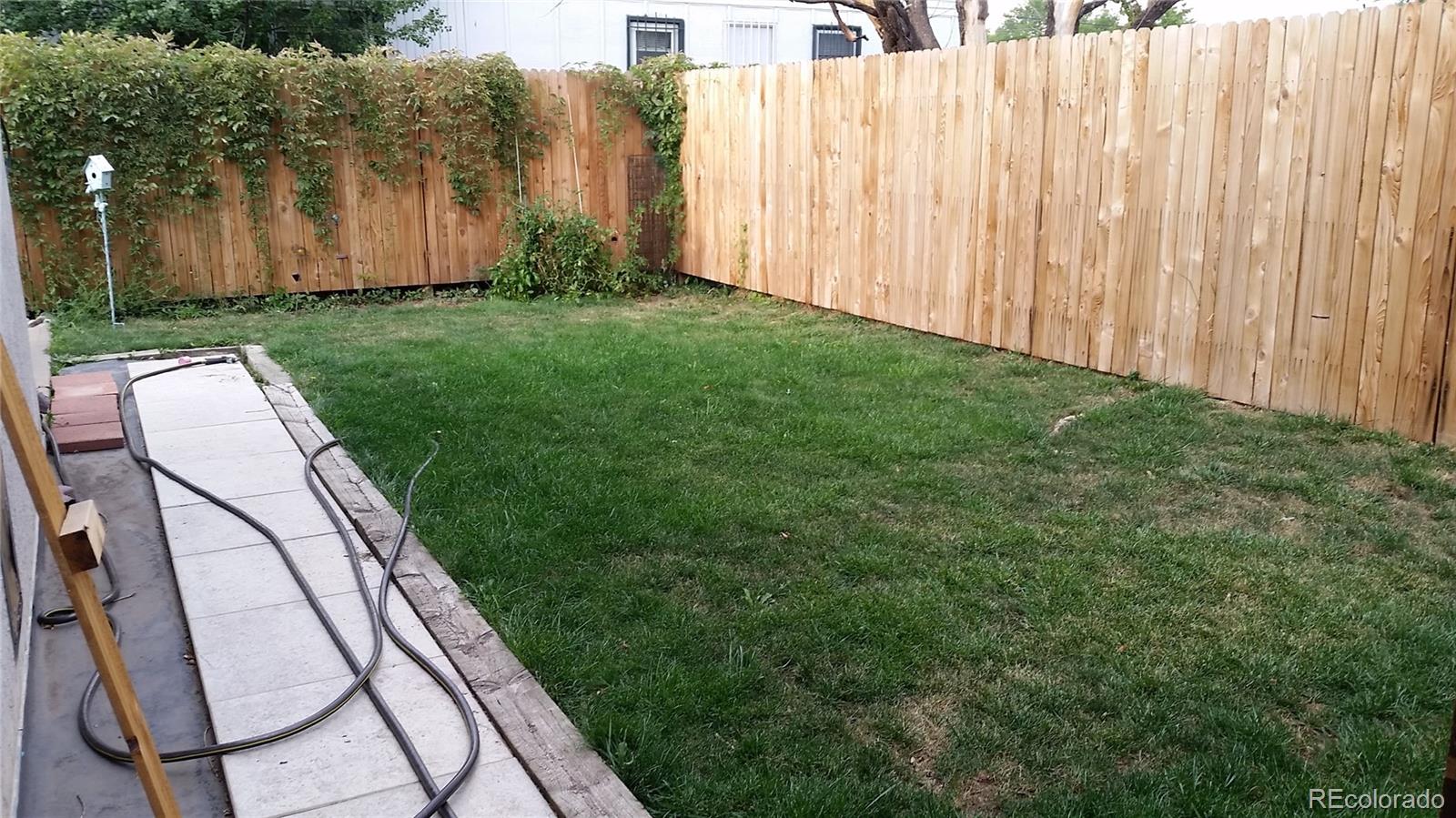 1910 South Decatur Street, Unit C Denver, CO 80219 - Photo 11 of 15 a backyard with plants and wooden fence
