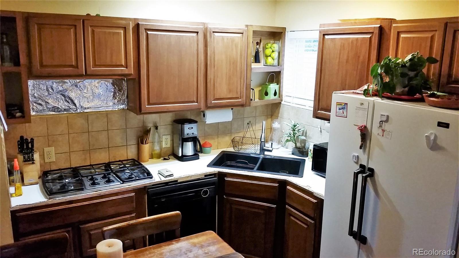 1910 South Decatur Street, Unit C Denver, CO 80219 - Photo 4 of 15 a kitchen with stainless steel appliances granite countertop a refrigerator stove and sink