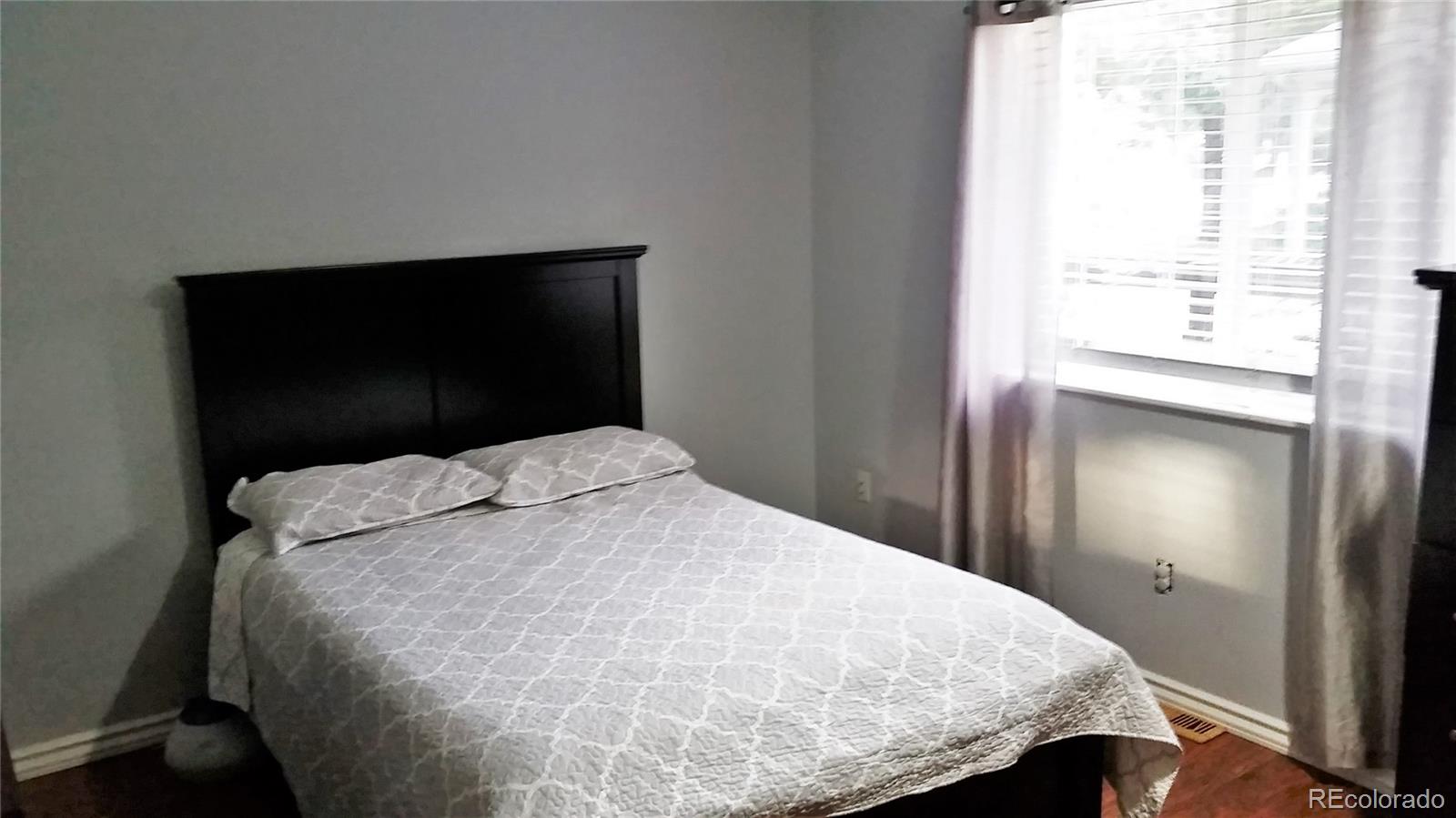 1910 South Decatur Street, Unit C Denver, CO 80219 - Photo 7 of 15 a bedroom with a bed and a window