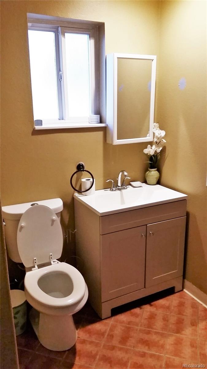 1910 South Decatur Street, Unit C Denver, CO 80219 - Photo 8 of 15 a bathroom with a toilet a sink and a mirror