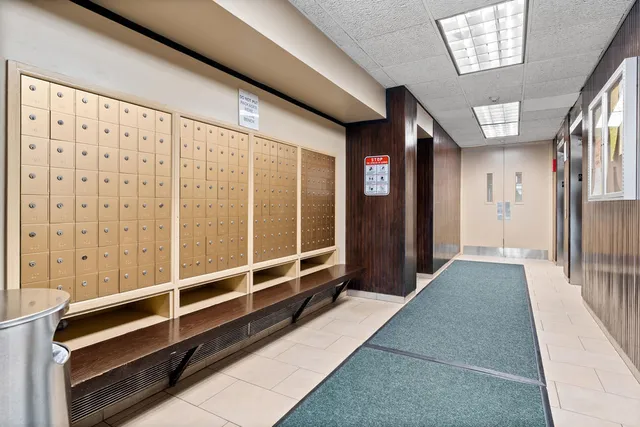 a room with a black white checkered floor storage cabinets and a dining table with wooden floor