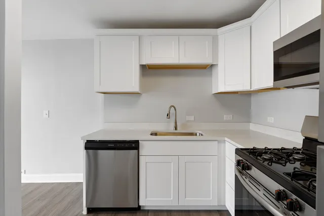a kitchen with stainless steel appliances white cabinets and a stove top oven