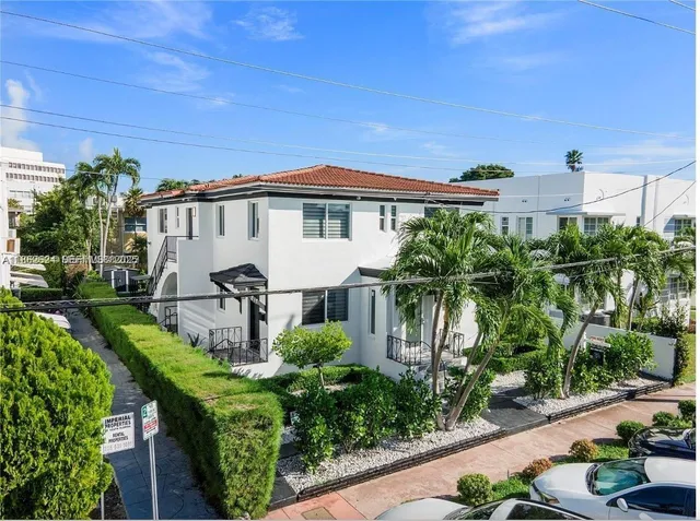 a white house with a yard and plants