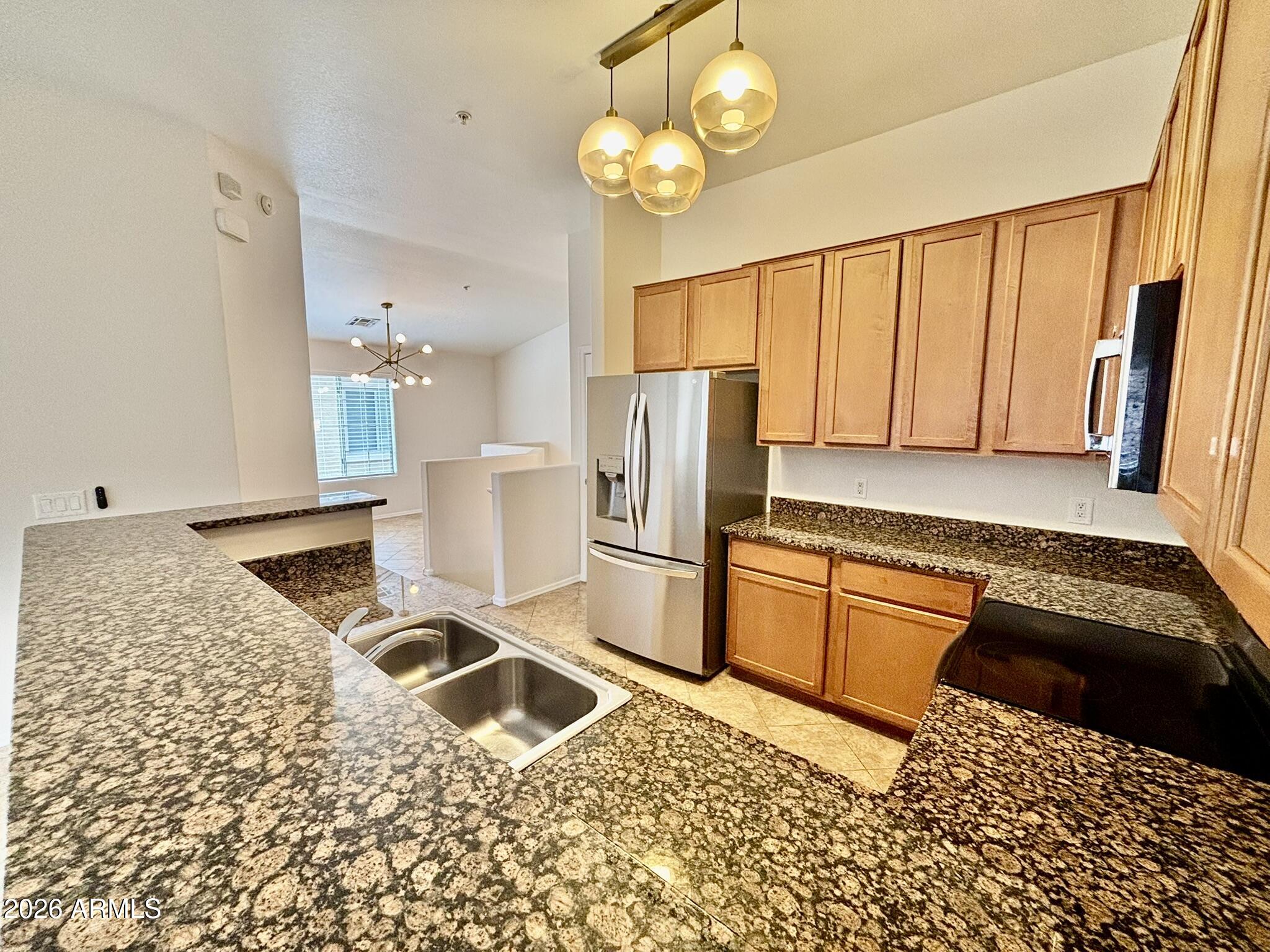 1350 South Greenfield Road, Unit 2041 Mesa, AZ 85206 - Photo 11 of 33 a kitchen with stainless steel appliances granite countertop a refrigerator sink and stove