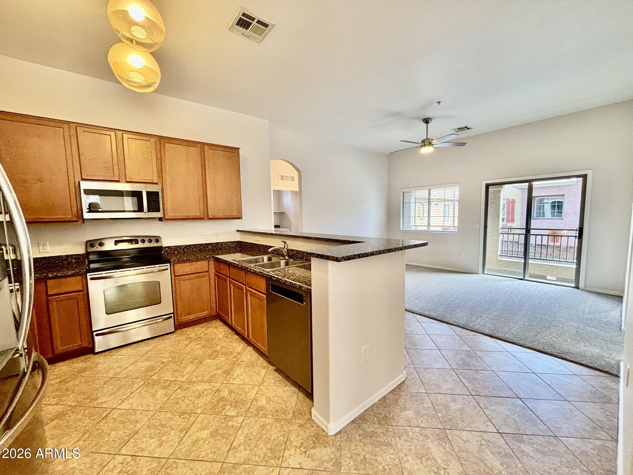 1350 South Greenfield Road, Unit 2041 Mesa, AZ 85206 - Photo 4 of 33 a kitchen with stainless steel appliances granite countertop a stove top oven a sink and dishwasher