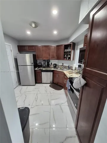 a kitchen with stainless steel appliances granite countertop a sink a stove and a refrigerator