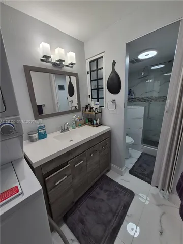 a bathroom with a sink a toilet and mirror