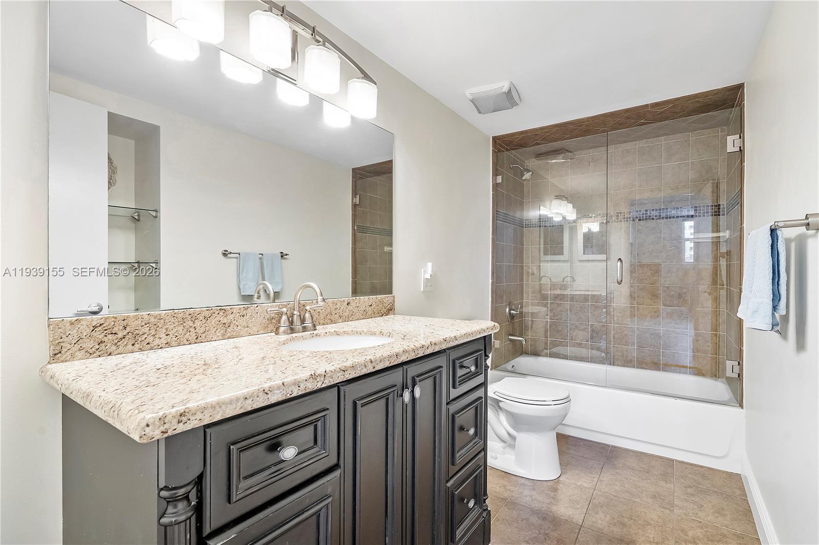 1401 South Ocean Drive, Unit 301 Hollywood, FL 33019 - Photo 27 of 48 a bathroom with a granite countertop sink a toilet and bathtub