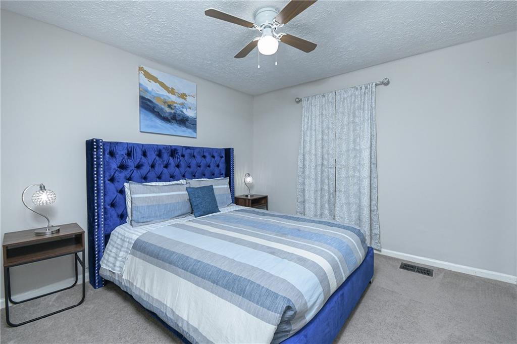 84 West Paulding Boulevard Dallas, GA 30157 - Photo 32 of 37 a bedroom with a bed and a chandelier
