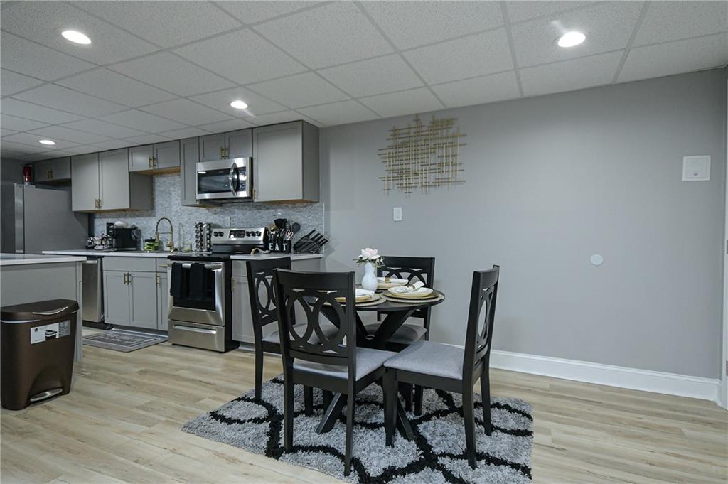 84 West Paulding Boulevard Dallas, GA 30157 - Photo 6 of 37 a kitchen with stainless steel appliances granite countertop a sink a stove a microwave a dining table and chairs