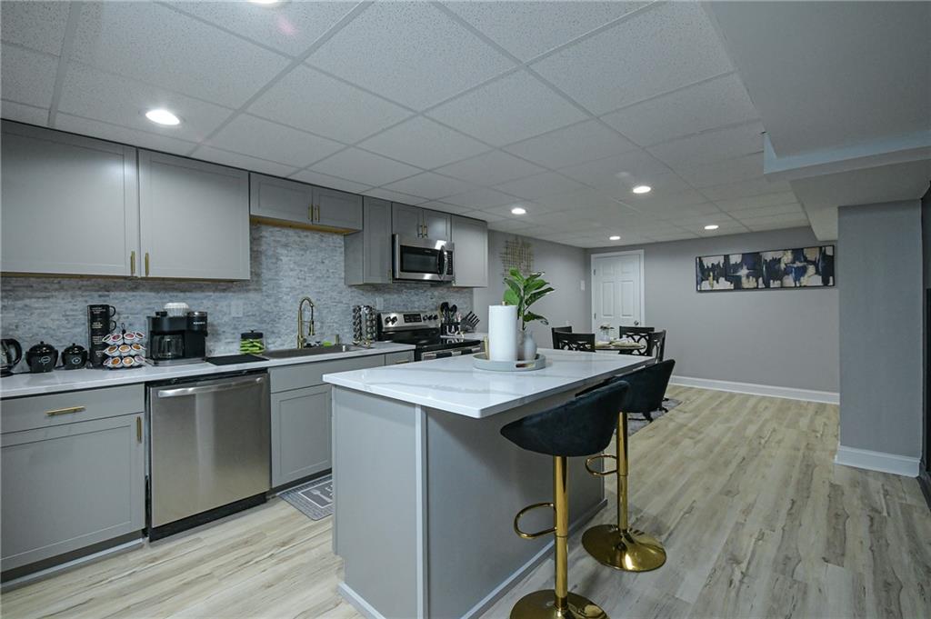 84 West Paulding Boulevard Dallas, GA 30157 - Photo 7 of 37 a kitchen with stainless steel appliances granite countertop a sink a stove a refrigerator cabinets and a dining table with wooden floor