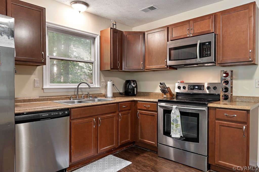 5022 Wilconna Road Chesterfield, VA 23832 - Photo 9 of 27 a kitchen with stainless steel appliances granite countertop a sink a stove a microwave and wooden cabinets