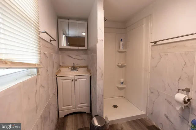 a bathroom with a shower a mirror and a sink