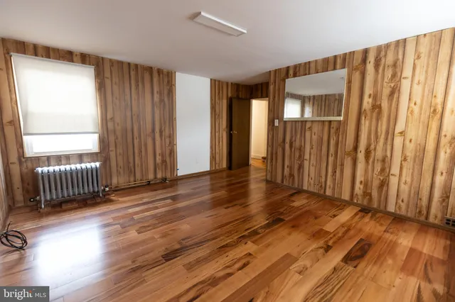 an empty room with wooden floor and a window