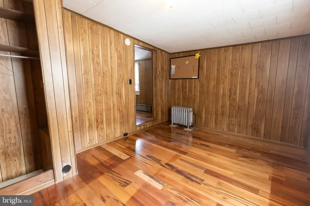a view of a bedroom with wooden floor and a window