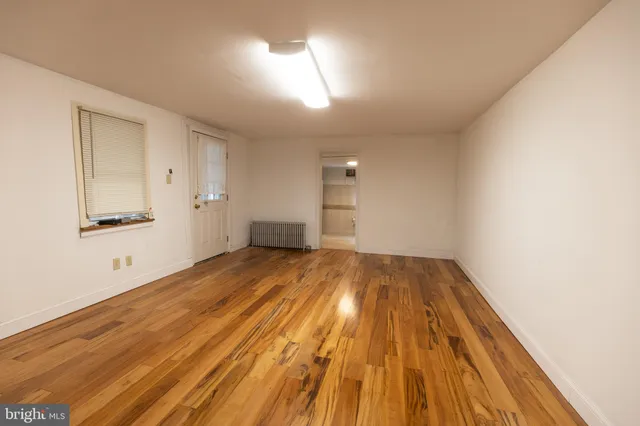 a view of empty room with wooden floor