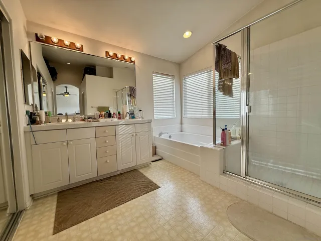 a bathroom with a double vanity sink mirror and bathtub
