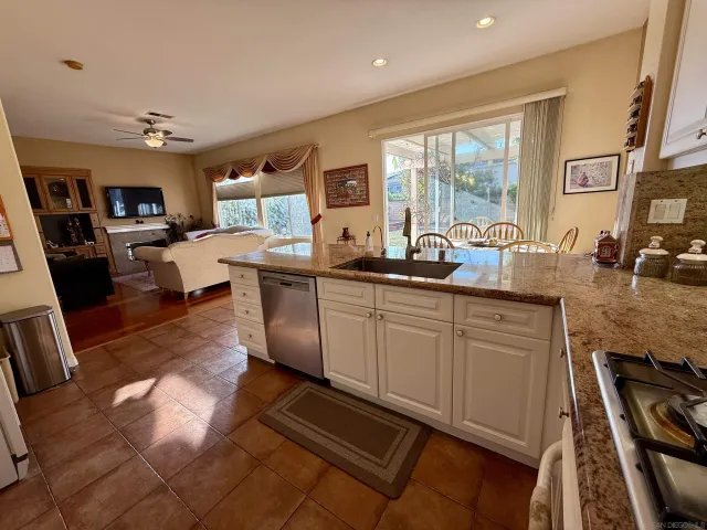a kitchen with stainless steel appliances granite countertop a sink counter space cabinets and a couch