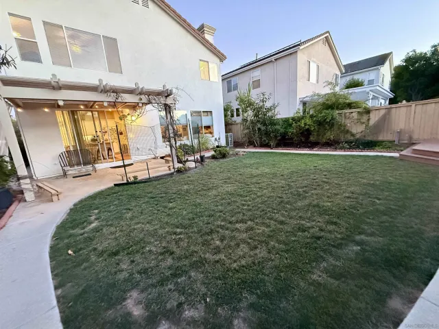 a view of a patio with table and chairs potted plants with wooden floor and fence