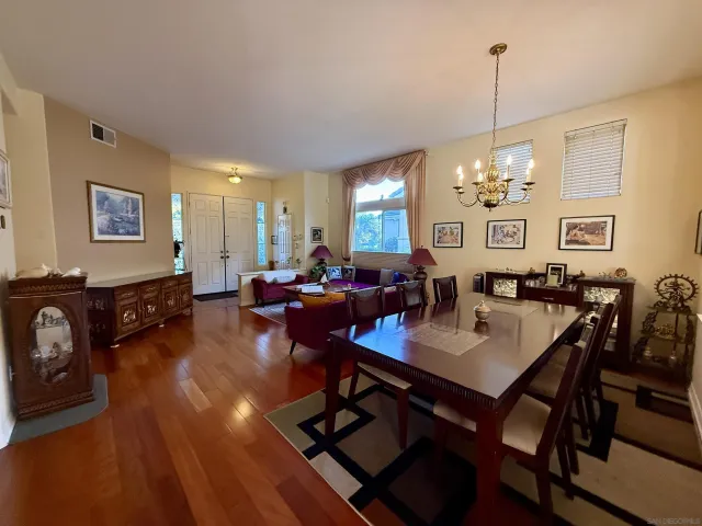 a view of a dining room with furniture a chandelier and wooden floor