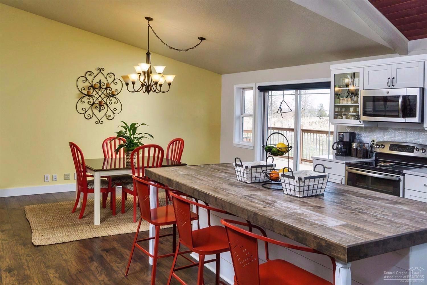 22224 Nelson Road Bend, OR 97701 - Photo 7 of 19 a view of a dining room with furniture a chandelier and wooden floor