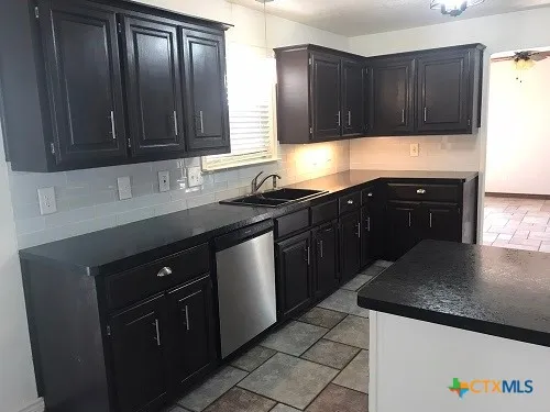 a kitchen with a sink and a stove top oven