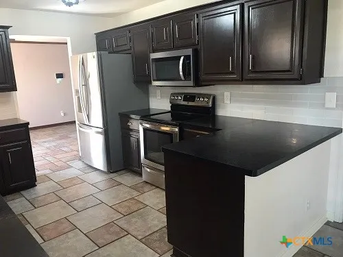 a kitchen with a refrigerator stove and microwave