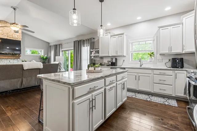 a kitchen with granite countertop a sink appliances cabinets and a counter top space