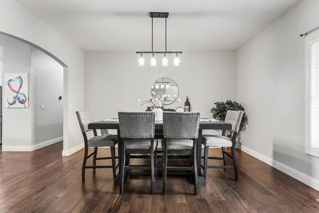 a view of a dining room with furniture a chandelier and wooden floor