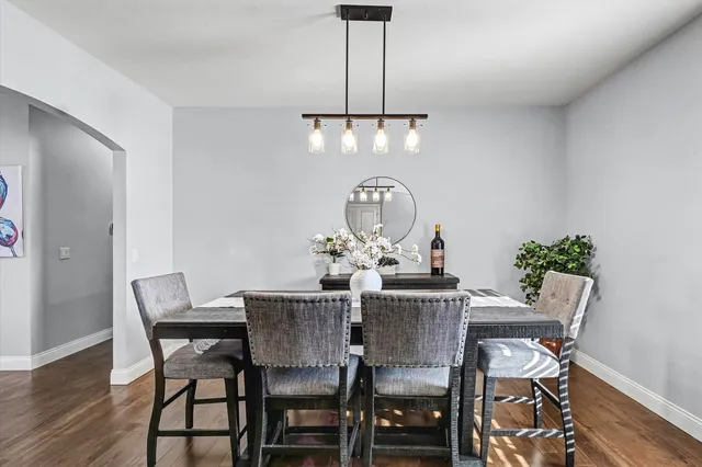 a view of a dining room with furniture a chandelier and wooden floor