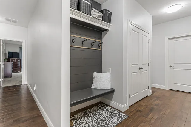 a hallway with white cabinets and wooden floor