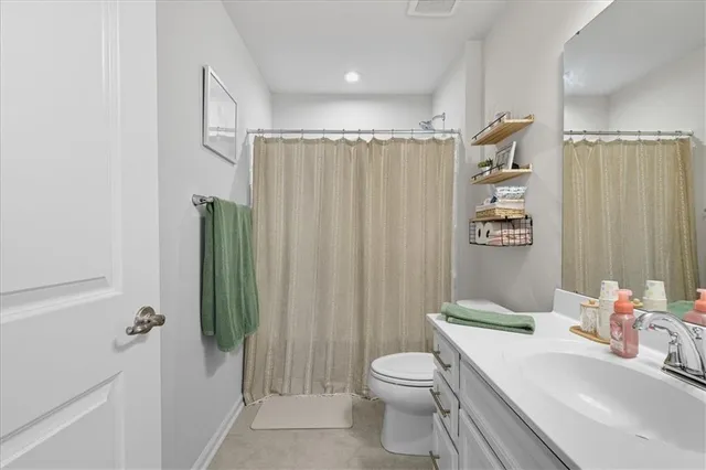 a bathroom with a sink a toilet a mirror and shower curtain