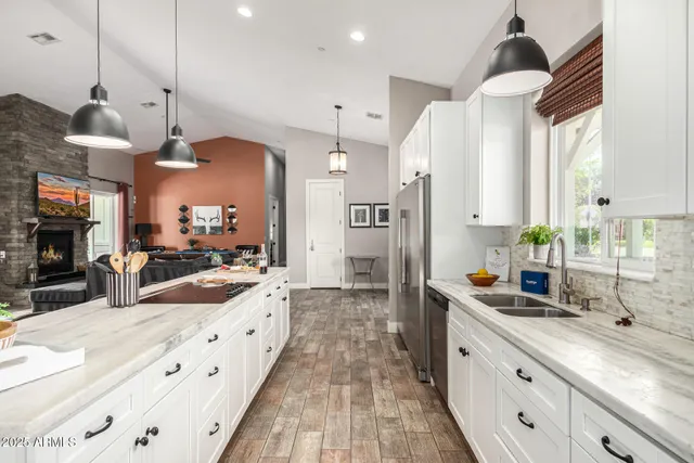 a large kitchen with granite countertop a sink and a stove top oven